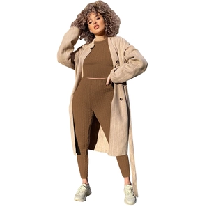 Détails de la maille du haut court marron et du legging avec manteau long à rayures