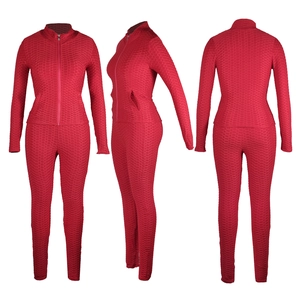 Détail de l'ensemble de yoga rouge avec tissu alvéolé et veste de sport ajustée