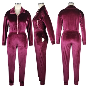 Detail view of burgundy velvet tracksuit with functional zippers and ribbed cuffs design