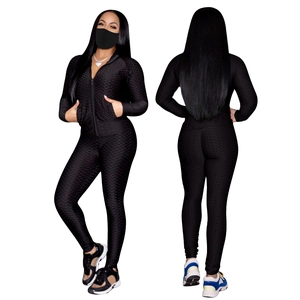 Détail d'un ensemble de yoga noir avec legging taille haute et veste à texture gaufrée