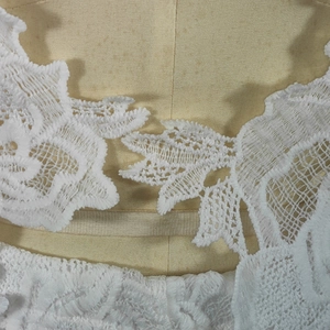 Macro shot of delicate white lace embroidery and floral pattern on these two-piece sets