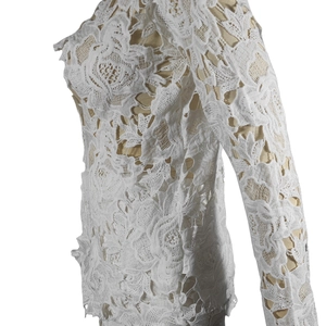 Detailed view of the intricate white floral lace texture and hollowed-out fabric patterns