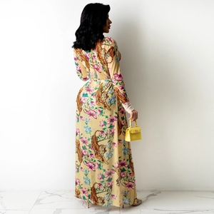 Detaillierte Nahaufnahme von Tiger- und Blumenmuster auf gelbem Langarm-Maxikleid