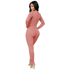 Gros plan sur la texture en maille torsadée rose de cet ensemble élégant en tricot