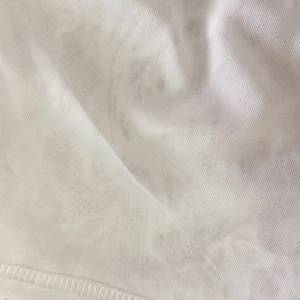 Macro shot of white knitted fabric texture with professional overlock stitching detail