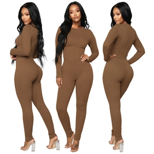 Détail du tissage en maille torsadée marron foncé sur cet ensemble pull ajusté