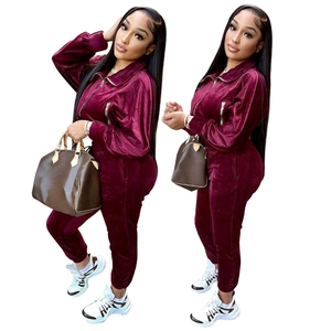 Burgundy velvet tracksuit featuring a zip-up jacket and jogger pants for women