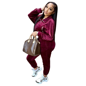 Detail of burgundy velvet tracksuit featuring a functional zipper and deep pockets