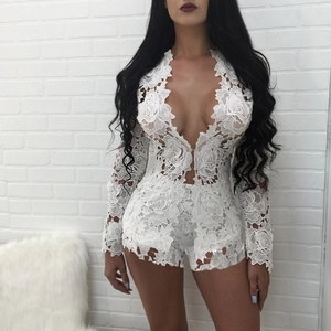 Close-up of white floral crochet lace fabric on a long sleeve deep V-neck romper