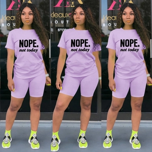 Dettaglio di un set sportivo due pezzi viola chiaro con stampa NOPE nera su maglietta e shorts