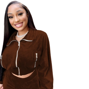 Detailed texture of brown velvet tracksuit jacket with functional metal zipper pockets