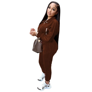 Detail shot of brown velvet tracksuit showing soft texture and functional zipper pocket
