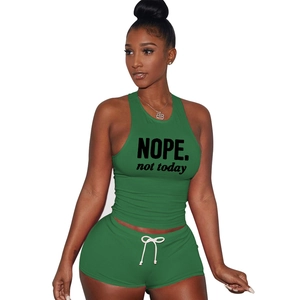 Close-up of green cotton two-piece set featuring NOPE slogan print and white drawstrings