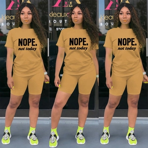 Dettaglio della stampa NOPE sul set sportivo due pezzi color cammello con shorts