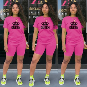 Détail d'ensemble sport rose avec imprimé couronne Queen, t-shirt et short cycliste