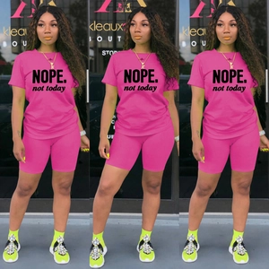 Dettaglio della t-shirt rosa con stampa NOPE e pantaloncini da ciclista coordinati