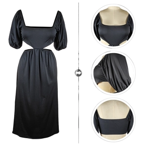 Détails de la robe noire à manches bouffantes, col en U et découpe à la taille