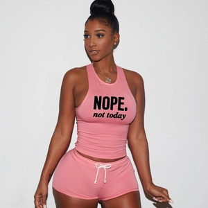 Detail of pink cotton two-piece set featuring 'NOPE' slogan print on crop tank top