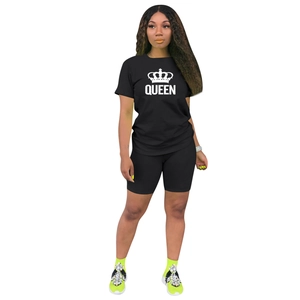 Détail de l'ensemble de sport noir avec imprimé couronne blanche et texte QUEEN sur un t-shirt