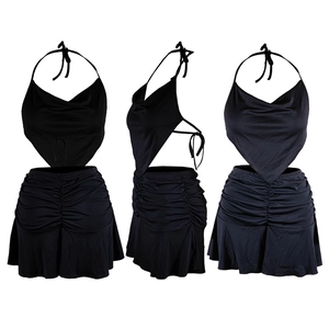 Detail of black two-piece halter set featuring backless top and ruched mini skirt