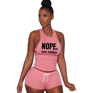 Detail of pink cotton lounge set showing 'NOPE.' text print on tank top and drawstring shorts