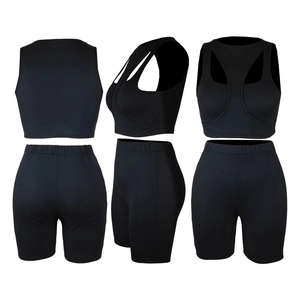 Driezijdige weergave van zwart geribbeld sportsetje met cropped top en korte strakke broek