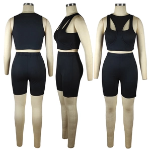 Detail van de zwarte geribbelde sportset met cross-back crop top en hoge shorts