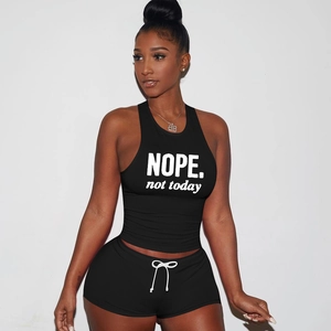 Detail of black sports set featuring crop top with NOPE print and matching shorts