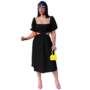 Détail d'une robe midi noire avec encolure carrée, manches bouffantes et taille ajourée