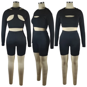 Three-view montage of a 3-piece black workout set with cutout shrug and shorts