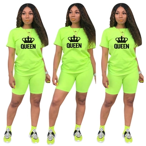 Détail du haut et du short de sport vert fluo avec imprimé couronne Queen