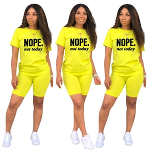 Dettaglio del set sportivo due pezzi giallo neon con scritte NOPE e pantaloncini