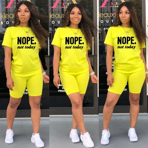 Dettaglio completo completo sportivo verde neon con stampa NOPE e pantaloncini biker
