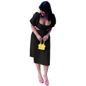 Vue détaillée de la robe noire à manches bouffantes, découpe à la taille et col carré
