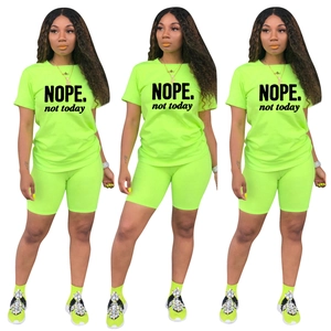 Completo due pezzi verde fluo con T-shirt stampa NOPE e pantaloncini da ciclista sportivi