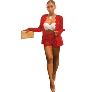 Detailed close-up of vibrant red lace blazer and matching shorts set with floral embroidery