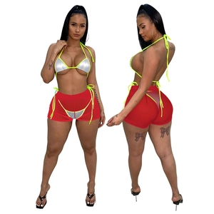 Dettaglio del top bikini argento metallizzato e pantaloncini in rete rossa con coulisse