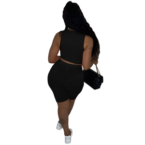 Achteraanzicht van zwarte geribbelde tweedelige sportset met crop top en biker shorts