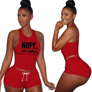 Detail of red athletic two-piece set featuring NOPE print crop top and drawstring shorts