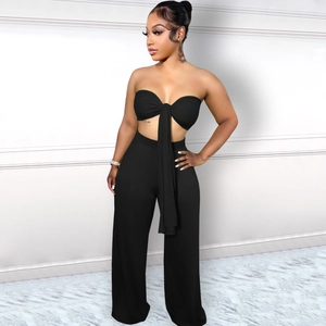 Détail d'un ensemble deux pièces noir avec haut court à nouer et pantalon large à taille haute