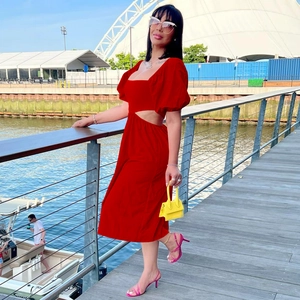 Détail des manches bouffantes et des découpes à la taille sur une robe midi rouge