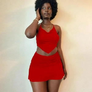 Detail of red two-piece set featuring halter neck tie top and ruched mini skirt