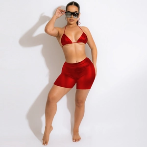 Detail of red metallic bikini set with high-waist shorts and shiny reflective fabric
