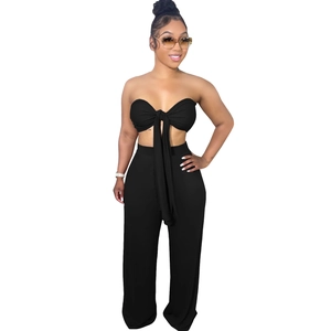 Détail de l'ensemble noir deux pièces avec haut bandeau à nœud et pantalon large à taille haute