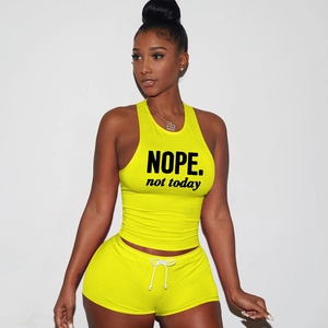 Close-up of neon yellow cotton sports set featuring NOPE print on the ribbed tank top
