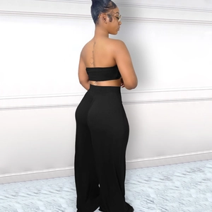 Détail du pantalon large à taille haute et du haut licou court en tissu noir