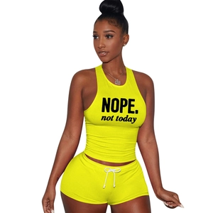 Detail of lemon yellow fitness set with NOPE printed crop top and slim shorts