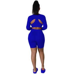 Back view of bright blue women's athletic set with long sleeve cutout top and high waist shorts