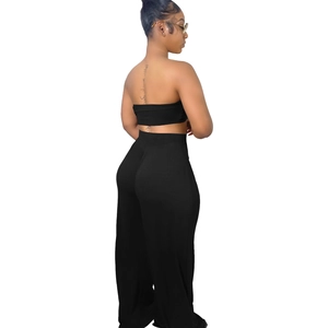 Vue latérale de l'ensemble deux pièces noir avec crop top bandeau et pantalon large taille haute