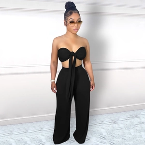 Détail d'un haut bustier noir avec nœud central et d'un pantalon large à taille haute